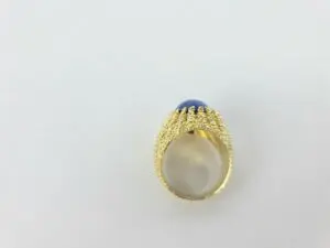 Gold ring with blue gemstone, textured band.