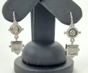 Silver ornate earrings with geometric designs.