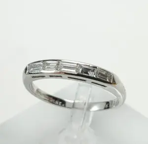 Silver ring with rectangular gemstones on display.