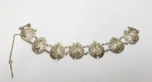 Ornate silver bracelet with floral design.