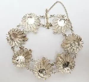 Silver floral bracelet with intricate details.