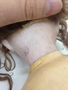 A woman with long hair is holding her head.