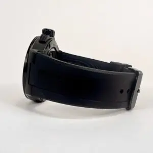 Black wristwatch with rubber strap, side view.