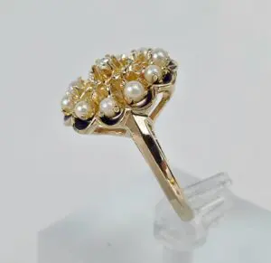 Gold ring with pearls on display stand.