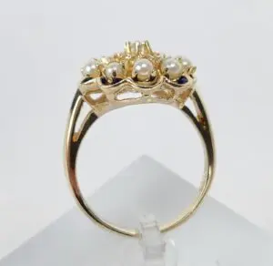 Gold ring with pearls and intricate design.