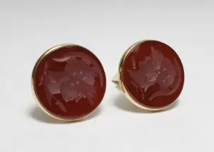 Red engraved round cufflinks with gold trim.