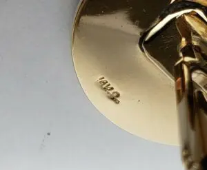 Gold-colored object with engraved numbers.