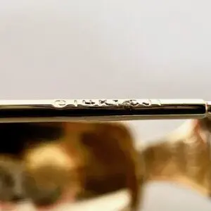 Close-up of engraved text on gold jewelry.
