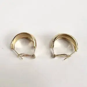 Gold hoop earrings on white background.