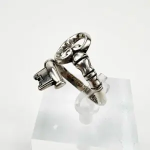 Silver ring with key and lock design.
