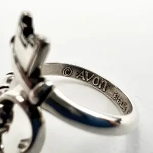 Silver ring with engraved Avon logo.