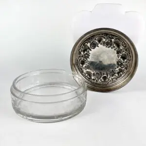 Glass bowl with ornate silver lid.