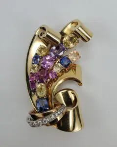 Gold brooch with colorful gemstones and diamonds.