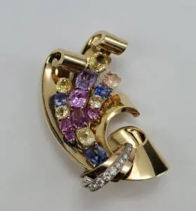 Gold brooch with colorful gemstones and diamonds.