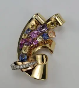 Gold brooch with colorful gemstones and diamonds.