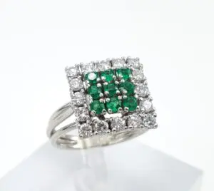Square diamond ring with green gemstones.