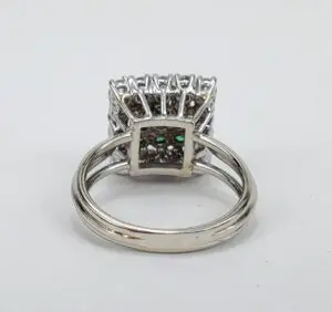 Silver ring with intricate square setting design.