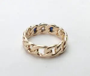 Gold chain-link ring with blue accents.