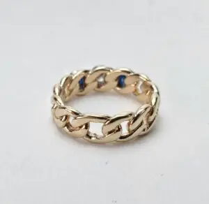 Gold chain link ring on white background.