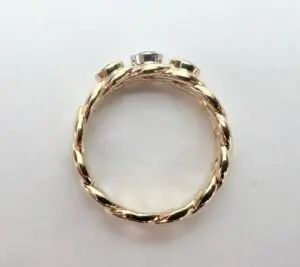 Gold twisted band ring with gemstones.
