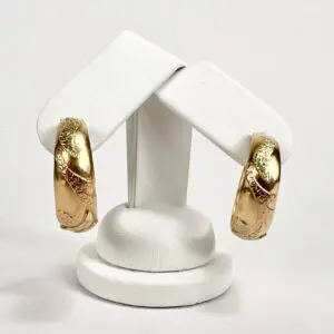 Gold hoop earrings on display stand.