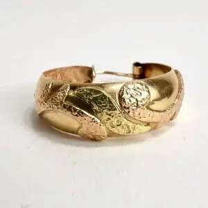 Gold textured bracelet with leaf design.