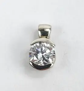 Silver pendant with a large round diamond.