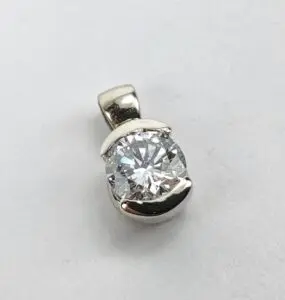 Silver pendant with a round diamond.