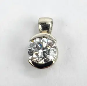 Silver pendant with large round diamond.