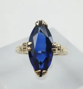 Gold ring with large blue gemstone.