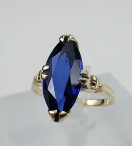 Gold ring with large blue gemstone.