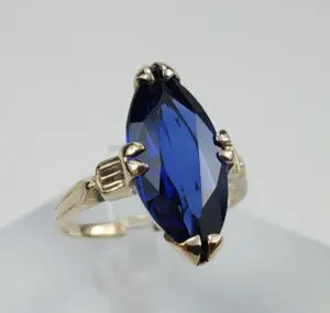 Gold ring with large blue gemstone.