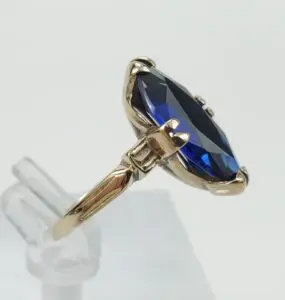 Gold ring with large blue gemstone.