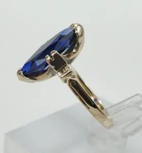 Gold ring with large blue gemstone.