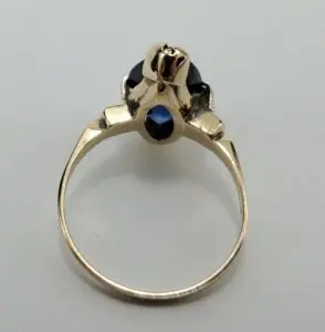 Gold ring with dark gemstone setting.