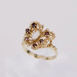 Gold ring with red and white gemstones.