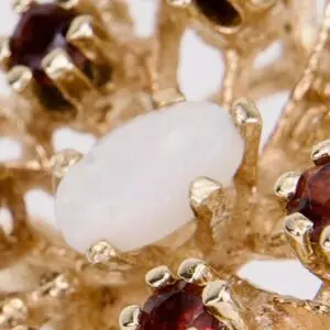 Gold ring with red and white gemstones.