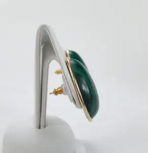 Green gemstone earrings on display stand.