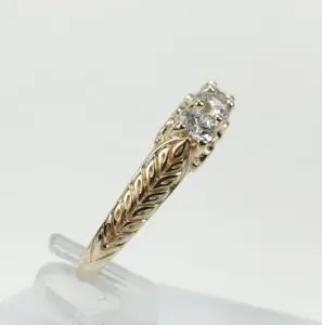 Gold ring with diamond and leaf design.
