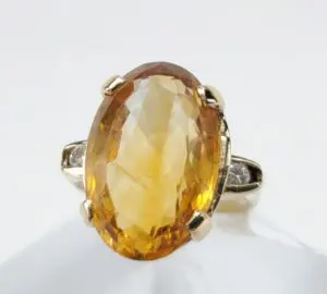 Oval amber gemstone ring with gold setting.