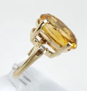 Gold ring with large yellow gemstone.