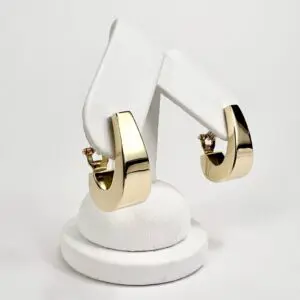 Gold hoop earrings on white display stand.