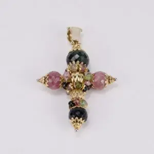 Intricate gemstone cross pendant on display.