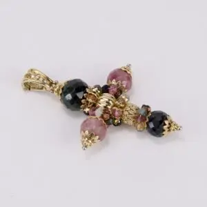 Ornate gemstone and gold cross pendant.