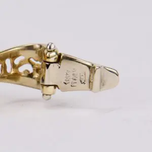 Gold bracelet clasp with engravings.