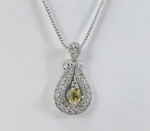 Diamond necklace with yellow gemstone pendant.