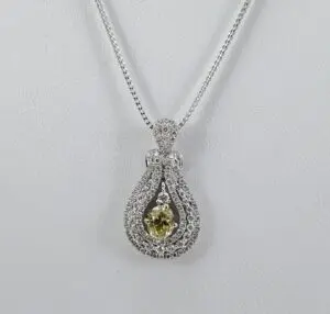 Diamond pendant necklace with yellow gemstone.