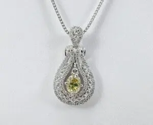 Silver necklace with green gemstone pendant.