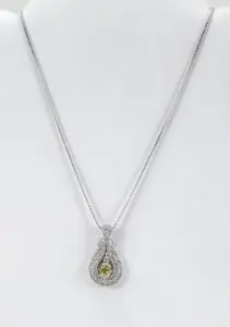Silver necklace with yellow gemstone pendant.