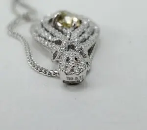 Diamond pendant with intricate design on chain.